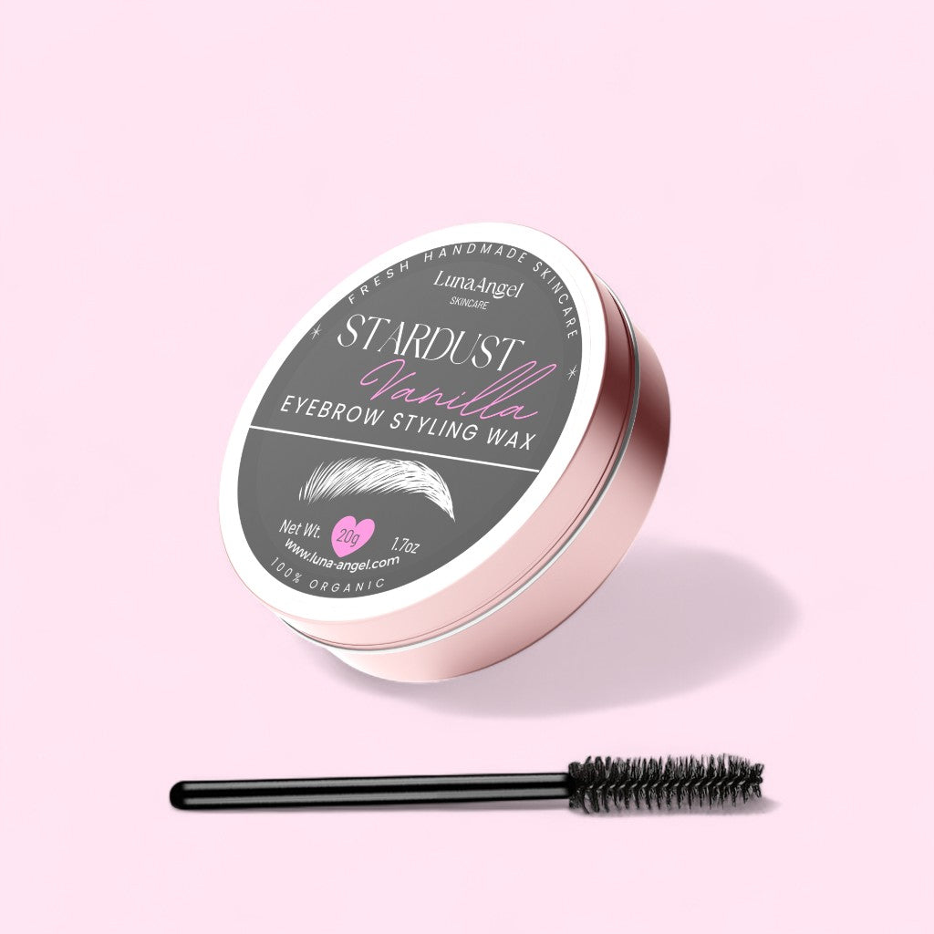Stardust Vanilla Eyebrow Styling Wax — round rose-gold tin with spoolie applicator on a pastel pink background