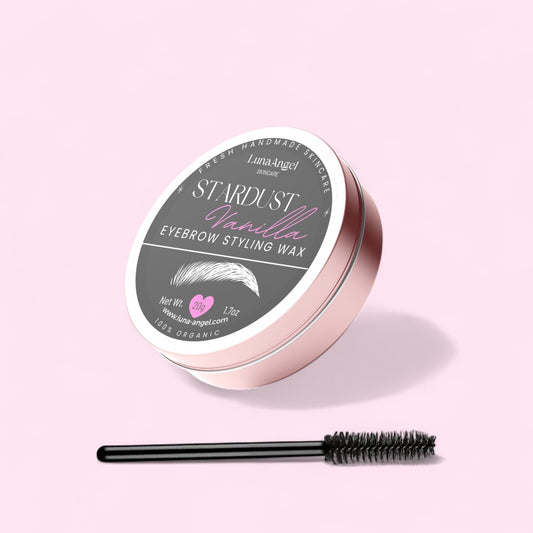 Stardust Vanilla Eyebrow Styling Wax — round rose-gold tin with spoolie applicator on a pastel pink background